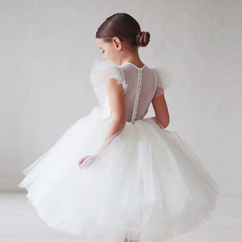 Back view of the white dress for girls showing the sheer illusion back and covered buttons.