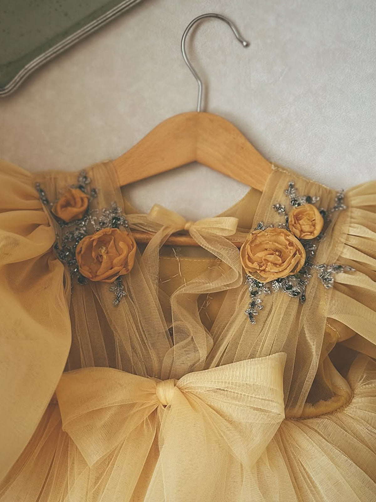 Golden yellow tulle girls dress back view with keyhole tie and big tulle bow, designed for flower girls and parties.