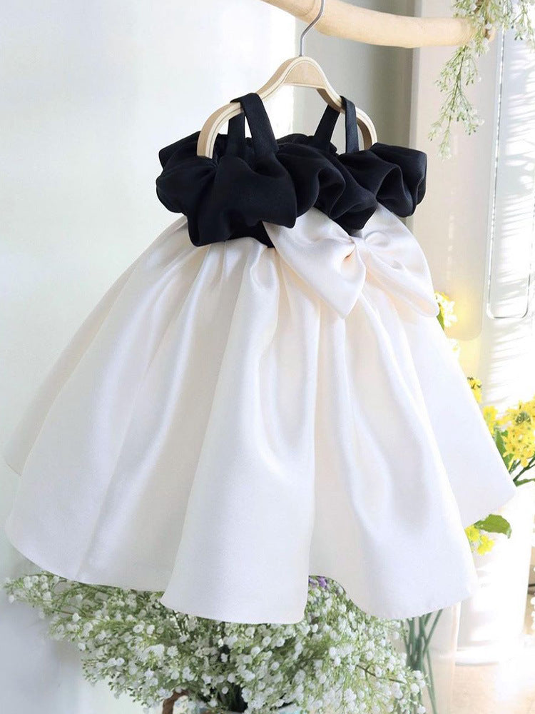 Ivory and black satin girls party dress with a gathered black ruffle band and a full skirt, designed for first birthdays and weddings.