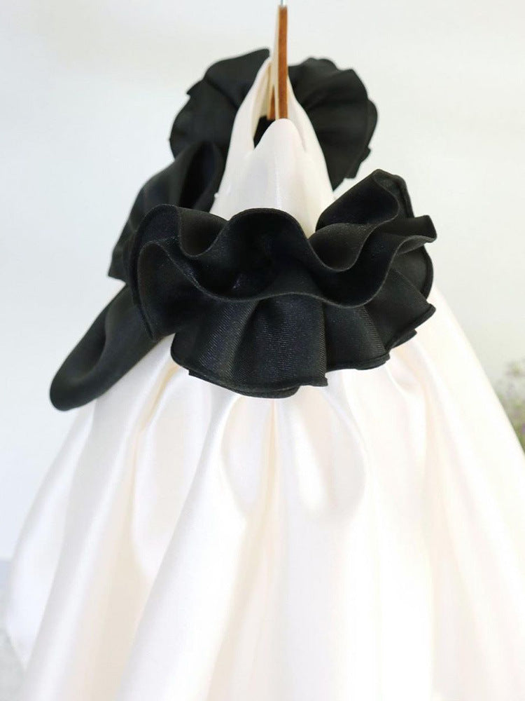 Ivory and black satin girls party dress with black ruffle bodice, detail view, designed for first birthdays.