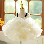 Ivory organza girls party dress with black velvet straps and a full ruffled skirt, designed for birthdays and photoshoots.