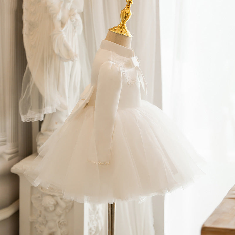 Ivory satin girls tutu dress side view with long sleeves and a full tulle skirt, designed for flower girls.
