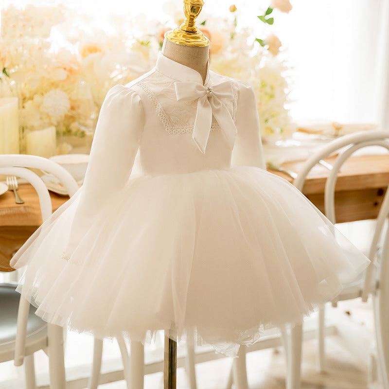 Ivory satin girls tutu dress with lace yoke and long sleeves, designed for first birthday parties.