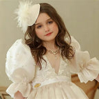 Close-up of the pearl beading and floral lace on the bodice of this white dress for girls.