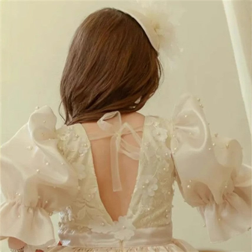 Pearl trimmed puff sleeves and the lace back panel on the ivory princess dress for girls.