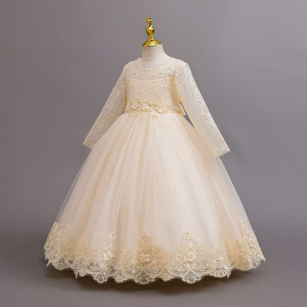 Champagne lace and tulle girls gown with long lace sleeves and a lace hem, designed for weddings and flower girls.