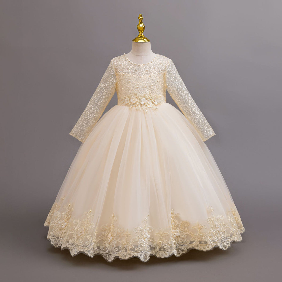 Champagne lace and tulle girls gown with long lace sleeves, a pearl-beaded bodice and a lace hem, designed for weddings and flower girls.