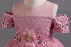Pink lace girls gown close-up of beaded off-shoulder sleeves and illusion neckline, designed for formal events.
