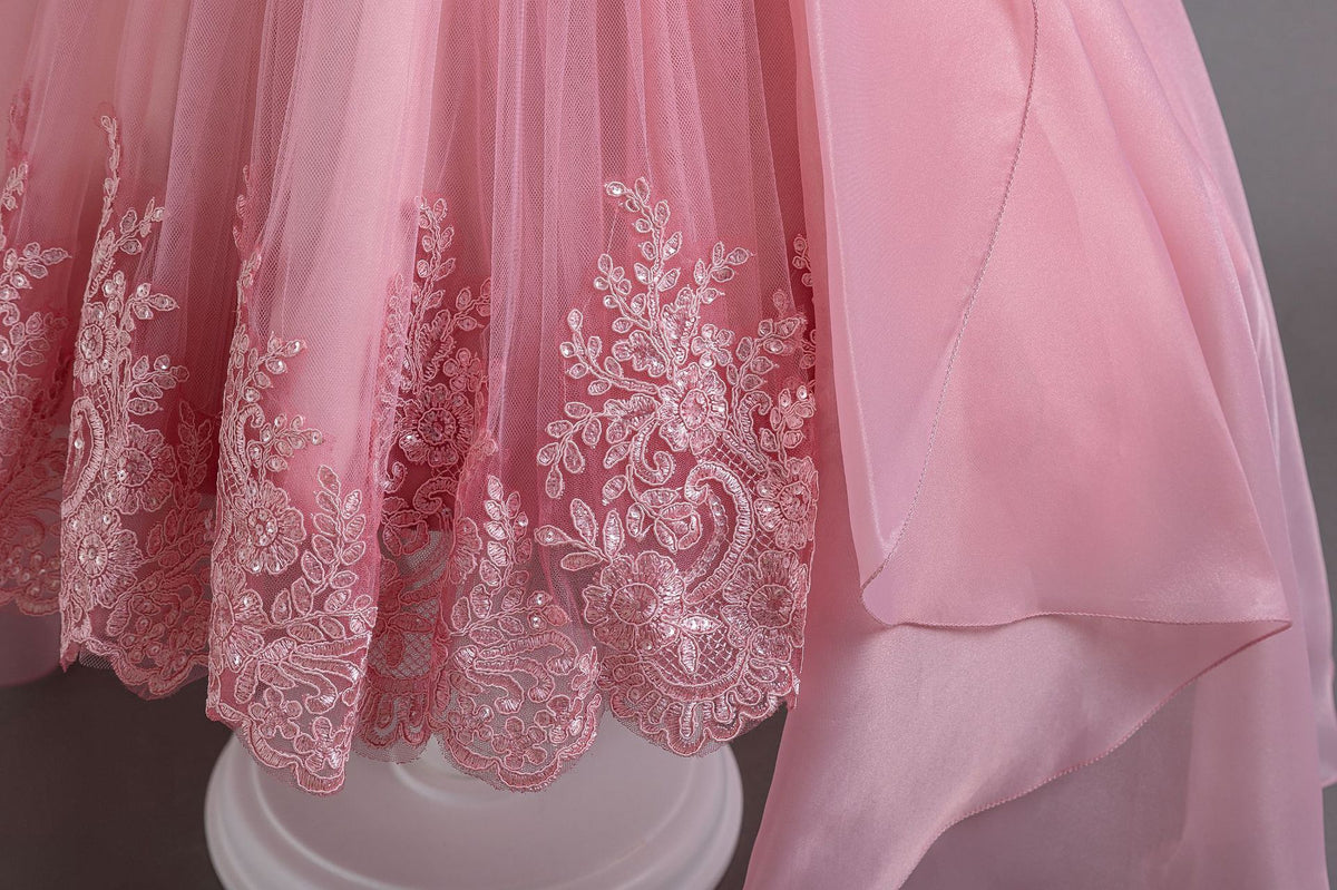 Pink lace girls gown close-up of the embroidered lace hem appliqué on tulle, designed for weddings and parties.