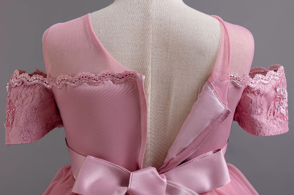 Pink lace girls gown close-up of the sheer mesh back and satin bow, designed for weddings and parties.