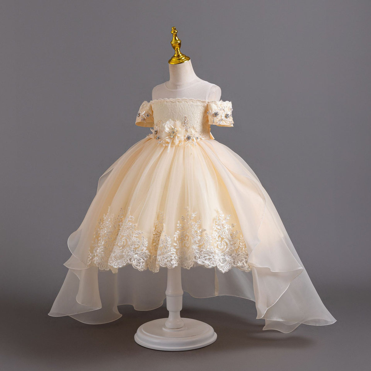 Champagne lace girls gown with organza train and lace hem appliqué, designed for weddings and pageants.