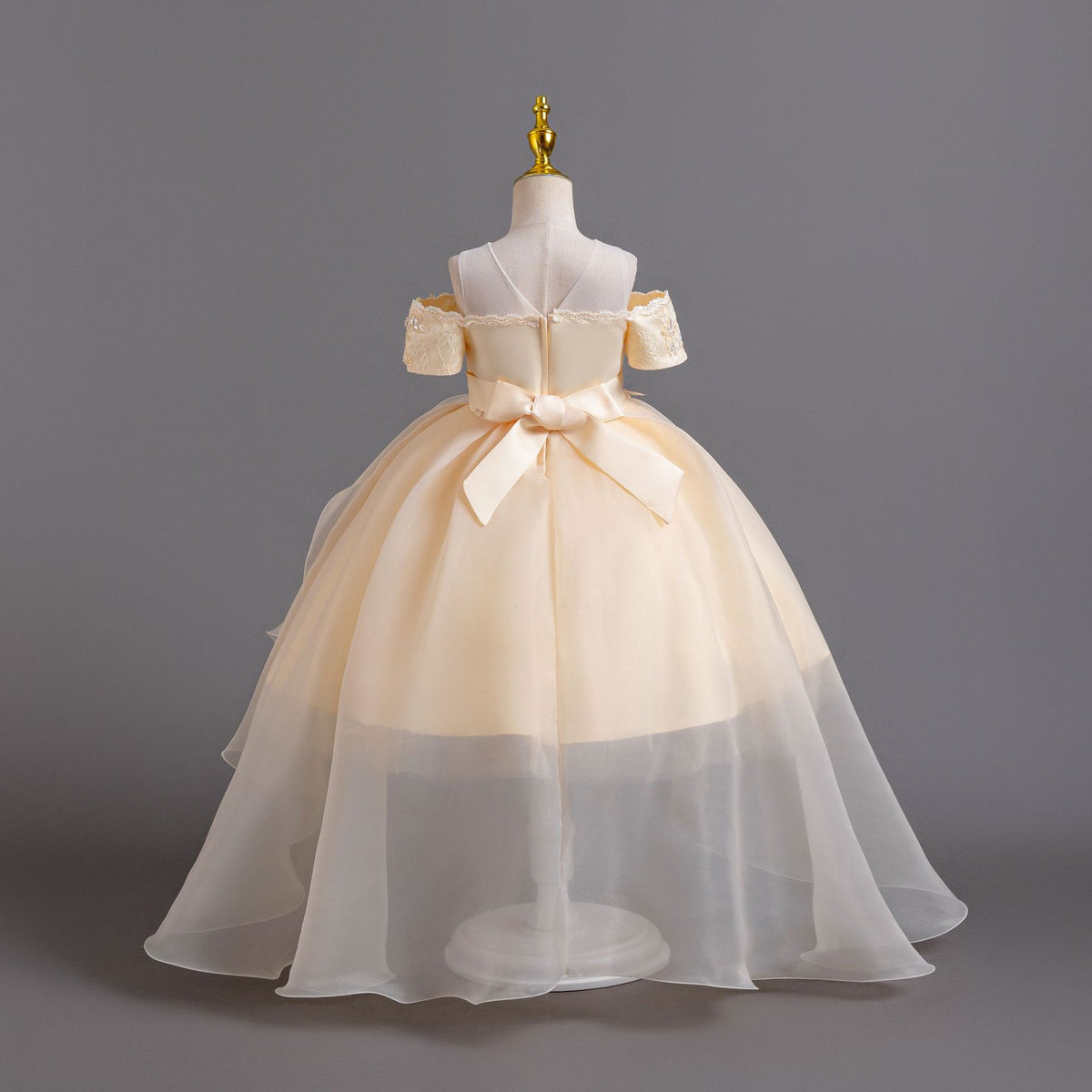 Champagne lace girls gown back view with satin bow and organza train, designed for weddings and pageants.