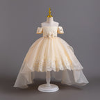 Champagne lace girls gown with off-shoulder beaded sleeves, floral waist and high-low organza train, designed for weddings and pageants.