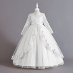 White lace and tulle girls ball gown with long sheer lace sleeves, sequin lace overlay trim and rhinestone waistband, designed for weddings and Christmas.