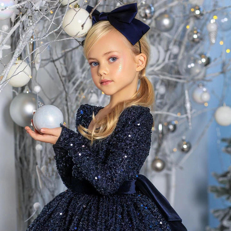 Navy sequin girls dress with long sleeves, open V-back and satin bow, designed for Christmas and holiday parties.