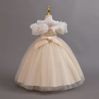 Champagne glitter tulle girls ball gown with a satin bow and zipper at the back, off-shoulder ruffles and full ball gown skirt, designed for birthdays, weddings and flower girls.