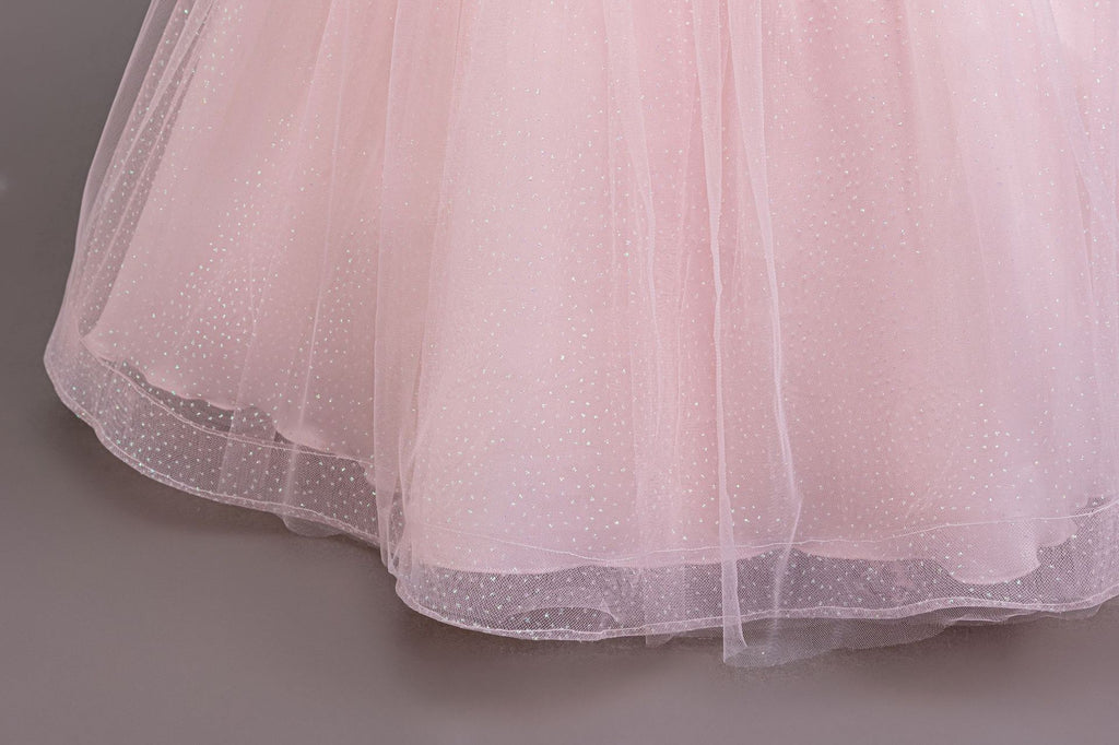 Pink glitter tulle skirt hem close-up on a girls ball gown, designed for parties and pageants.
