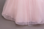 Pink glitter tulle skirt hem close-up on a girls ball gown, designed for parties and pageants.