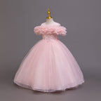 Pink tulle girls ball gown with off-shoulder ruffle neckline, beaded lace waist and back bow, designed for flower girls and birthdays.