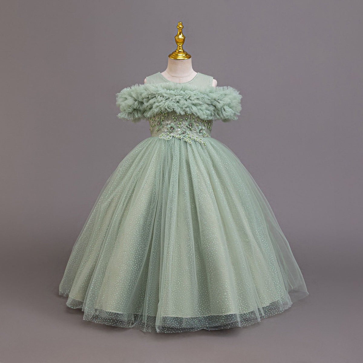 Sage green tulle girls ball gown with off-shoulder ruffle neckline, lace waist and back bow, designed for weddings and parties.