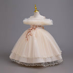 Champagne tulle girls ball gown with ruffled off-shoulder neckline, floral appliqué and satin bow back, designed for weddings and parties, view 2