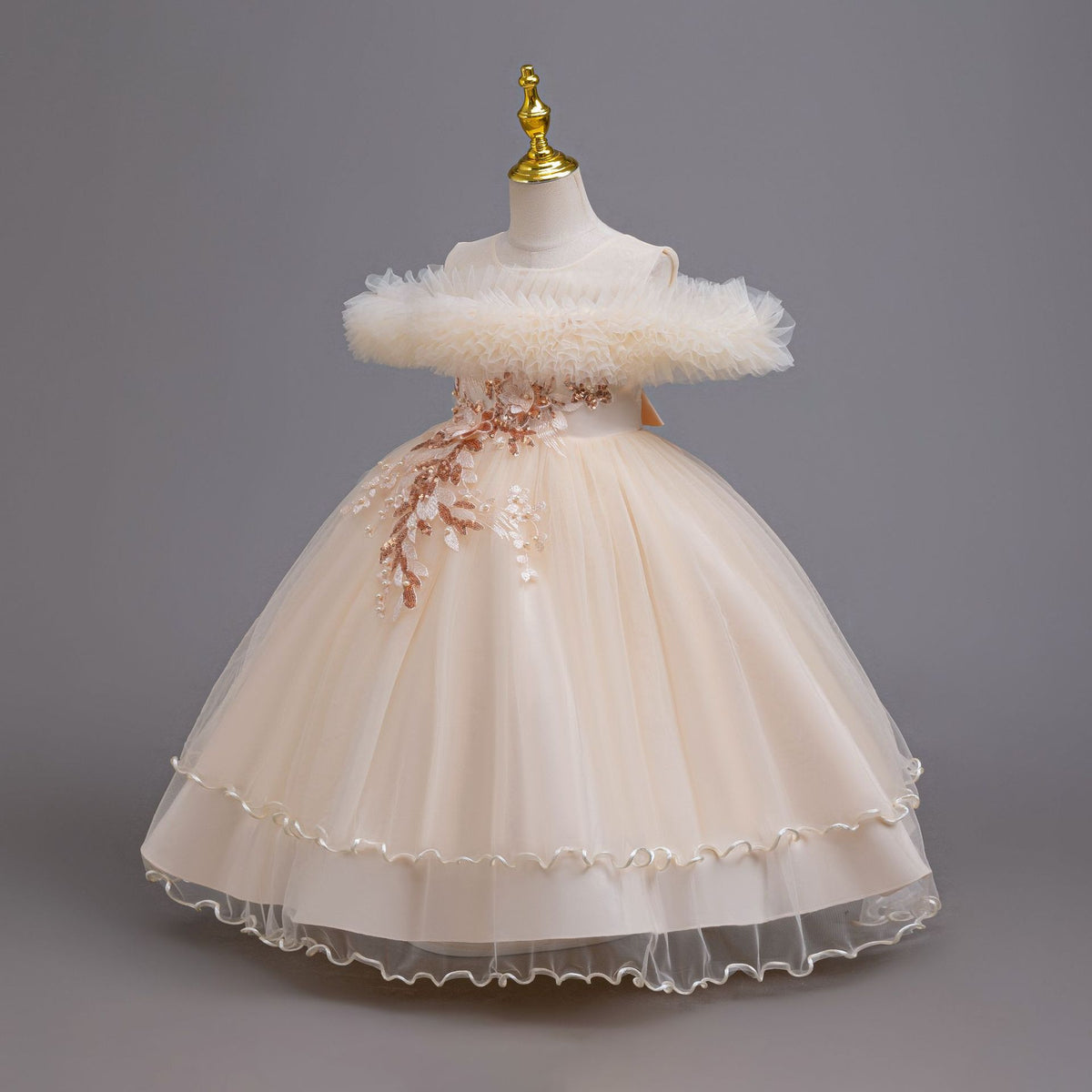 Champagne tulle girls ball gown with ruffled off-shoulder neckline, floral appliqué and satin bow back, designed for weddings and parties, view 2