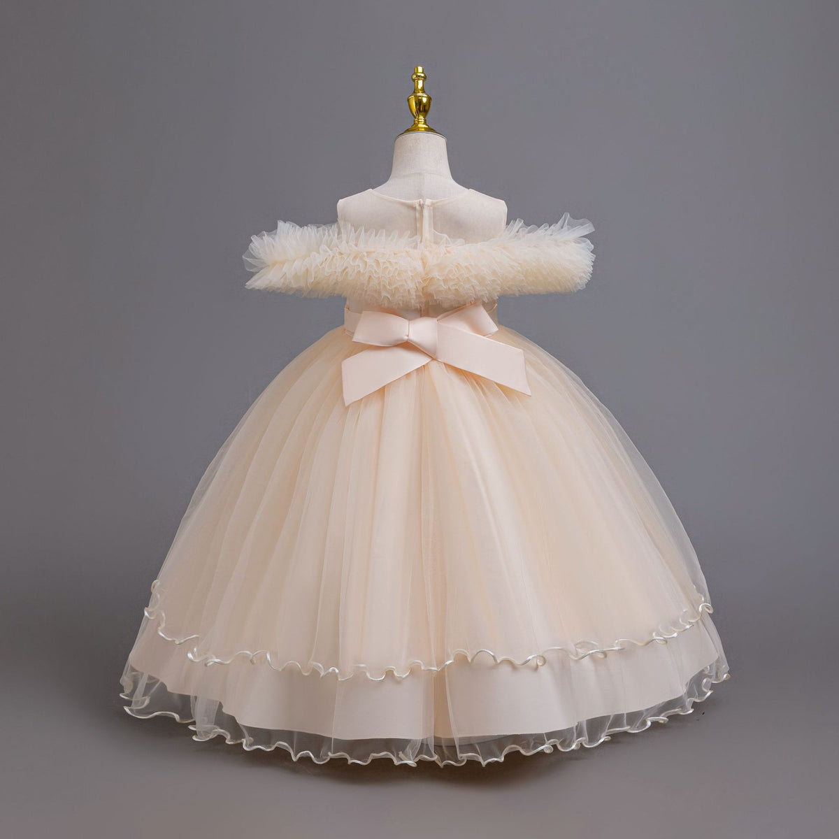 Champagne tulle girls ball gown with ruffled off-shoulder neckline, floral appliqué and satin bow back, designed for weddings and parties, view 4
