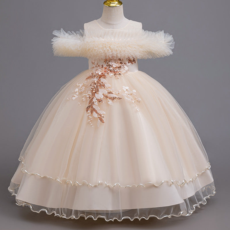 Champagne tulle girls ball gown with ruffled off-shoulder neckline, floral appliqué and satin bow back, designed for weddings and parties.