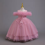 Mauve tulle girls ball gown with ruffled off-shoulder neckline, floral appliqué and satin bow back, designed for weddings and parties.