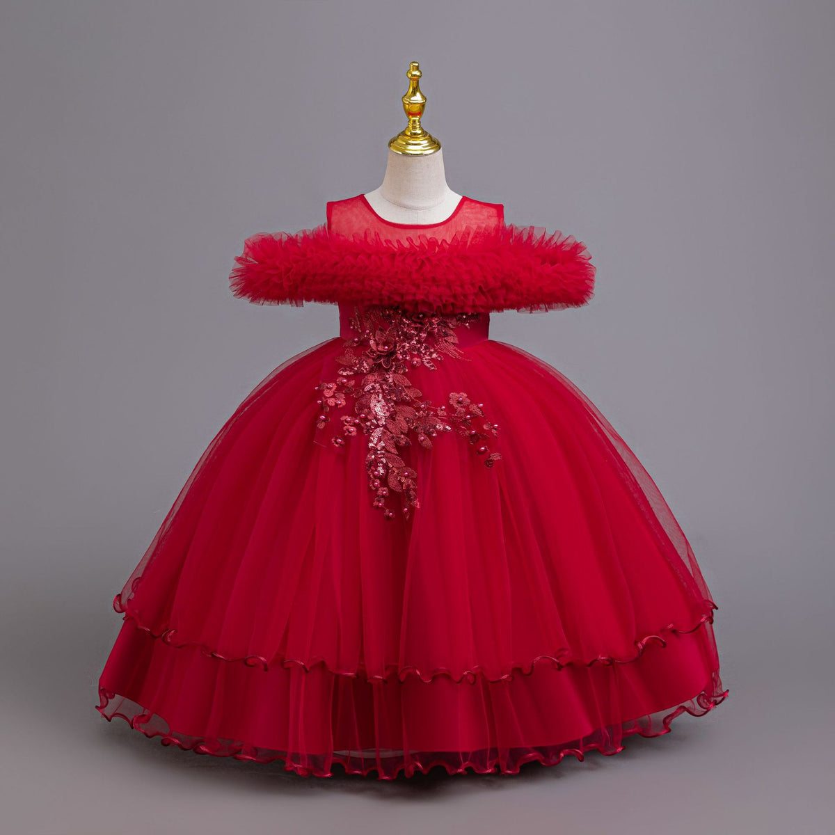 Red tulle girls ball gown with ruffled off-shoulder neckline, floral appliqué and satin bow back, designed for weddings and parties.