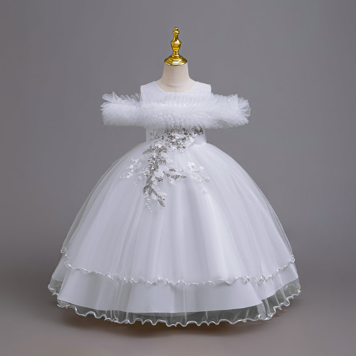 White tulle girls ball gown with ruffled off-shoulder neckline, floral appliqué and satin bow back, designed for weddings and parties.
