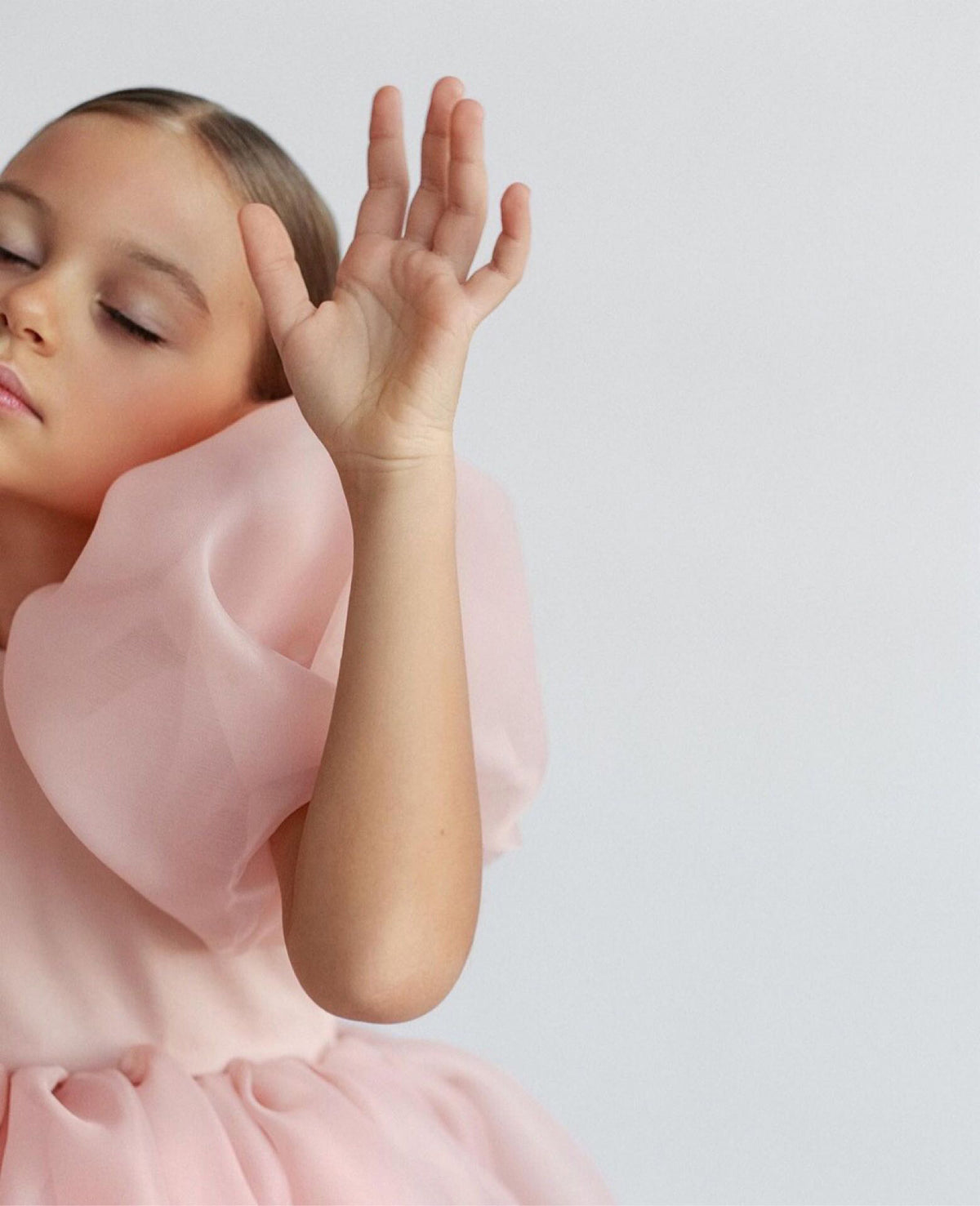 White organza girls dress with puff sleeves and swirling skirt, designed for flower girls and first birthdays.