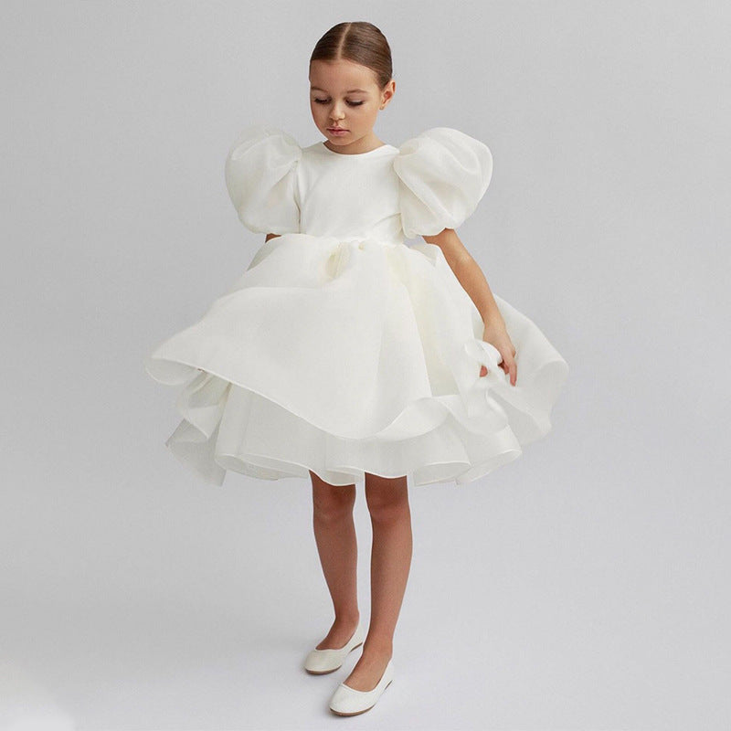 White organza girls dress with round neck and short puff sleeves, designed for weddings.