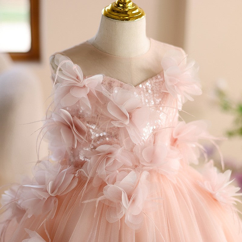 Close-up of the sequin sweetheart bodice and 3D flowers with feather wisps on the pink girls formal dress.