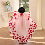 Back view of the pink and black girls formal dress showing the oversized pink bow at the waist and the long sheer tulle train.