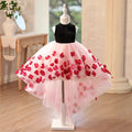 Pink and black tulle flower girl dresses with a black velvet mock neck bodice and 3D red flower appliques on a high-low skirt, front view, for weddings.
