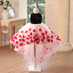 Pink and black tulle flower girl dresses with a black velvet mock neck bodice and 3D red flower appliques on a high-low skirt, front view, for weddings.