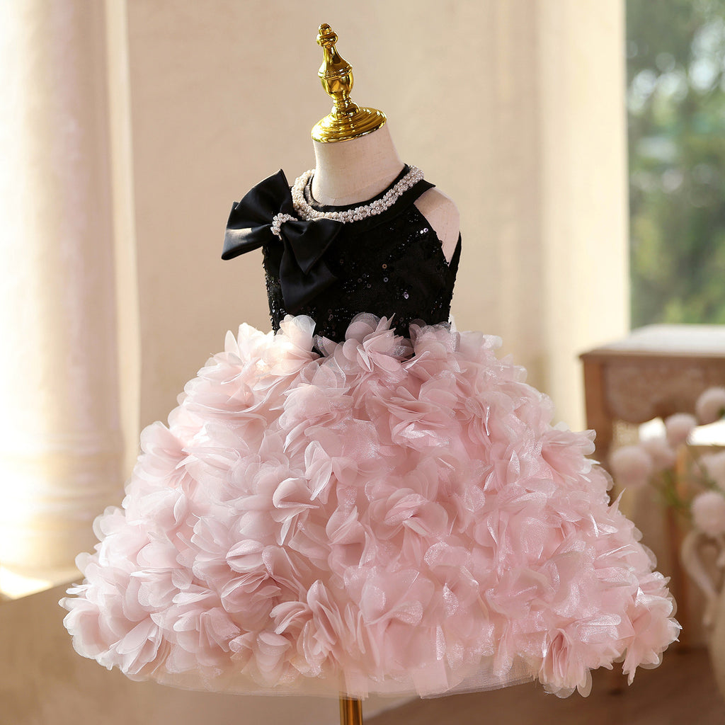 Pink and black sequin girls party dress with oversized satin bow and full petal skirt, designed for birthdays and recitals.