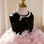 Close-up of pink and black girls party dress with sequin bodice, pearl-beaded neckline and black satin bow, designed for photoshoots.