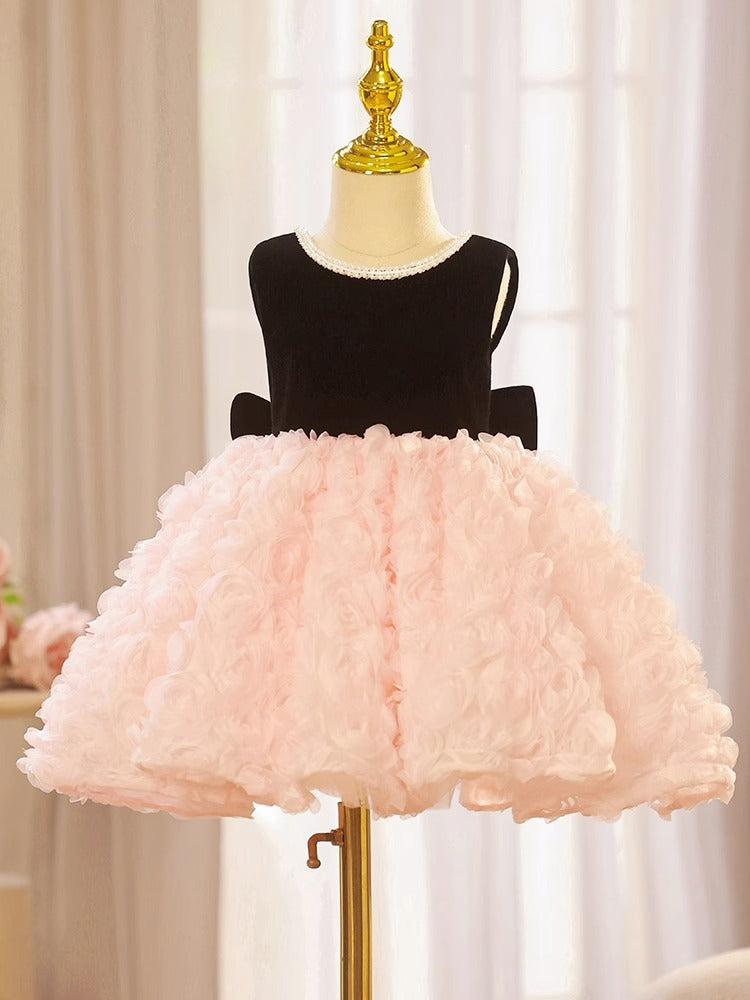 Pink and black velvet and tulle girls party dress with a pearl-trimmed neckline, 3D rosette skirt and big back bow, designed for birthdays and weddings.