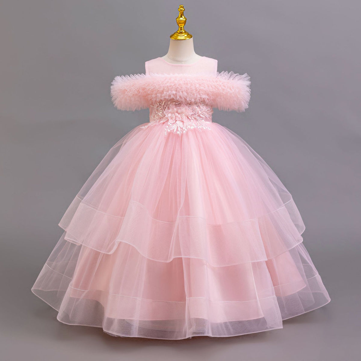 Pink tulle girls ball gown with ruffled off-shoulder neckline and layered tulle skirt, designed for birthdays and parties.