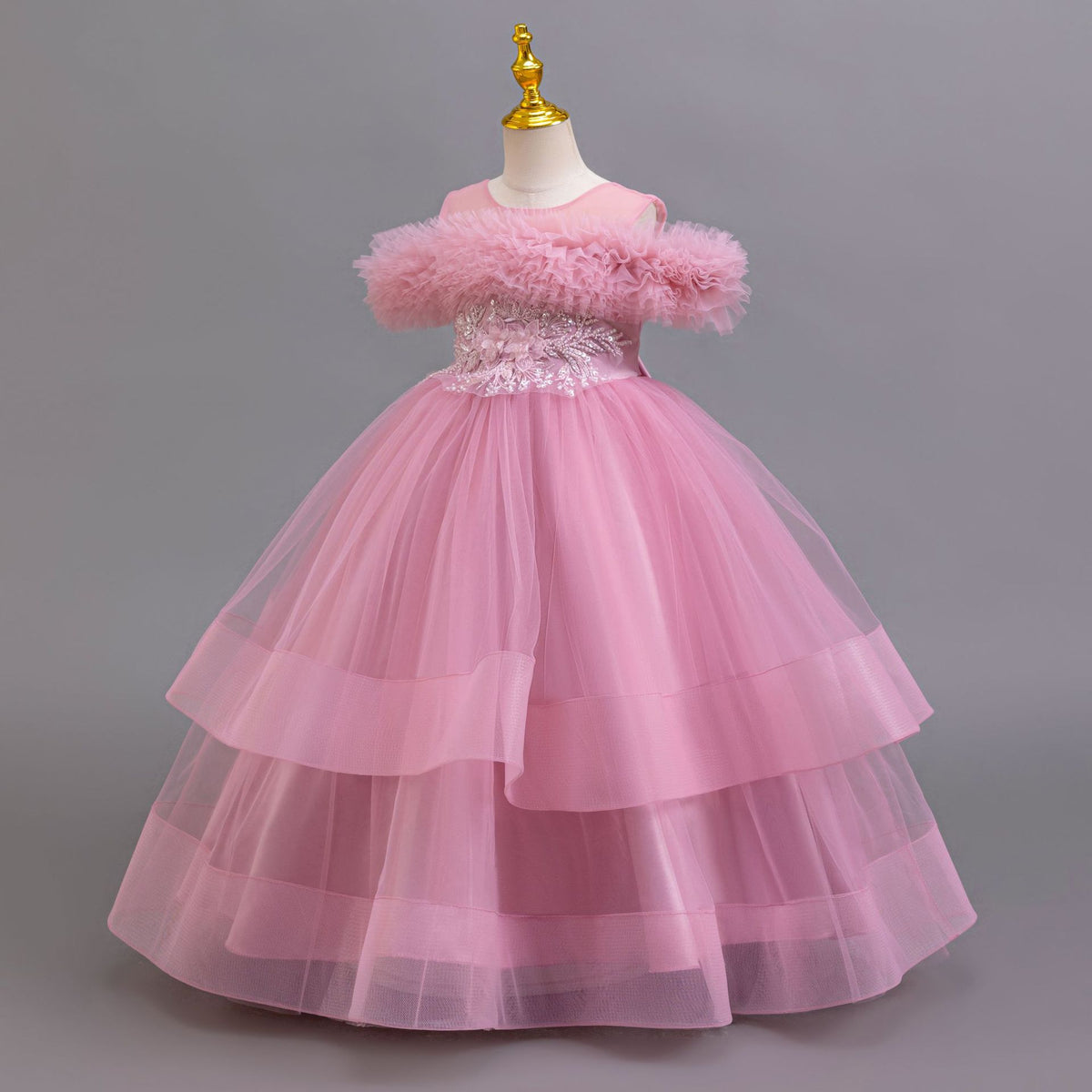 Mauve tulle girls ball gown with off-shoulder ruffle neckline and three-tier tulle skirt, designed for parties and recitals.