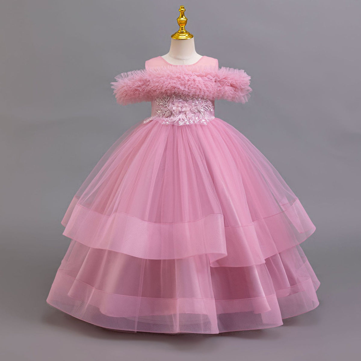 Mauve tulle girls ball gown with off-shoulder ruffle neckline, beaded lace waist and three-tier skirt, designed for weddings and pageants.