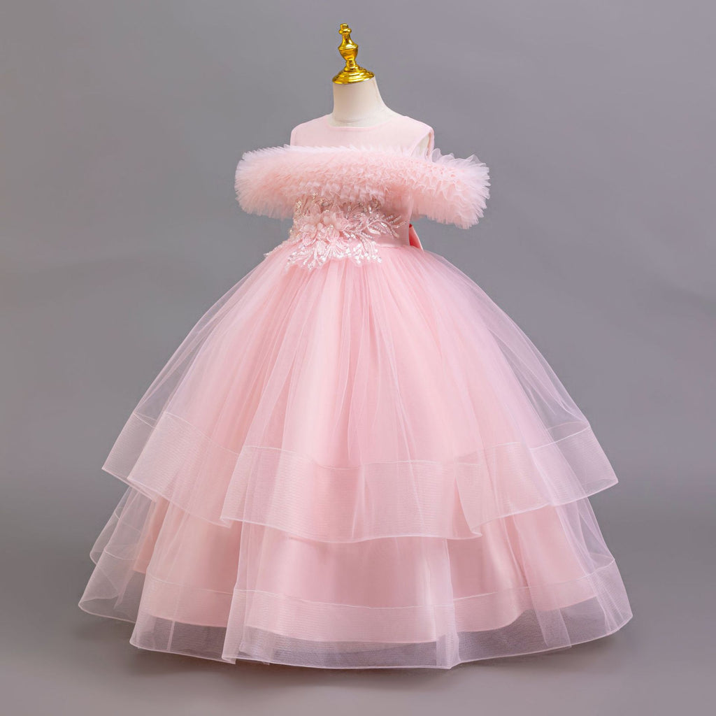 Pink tulle girls ball gown with off-shoulder ruffle neckline, beaded lace waist and three-tier skirt, designed for weddings and flower girls.