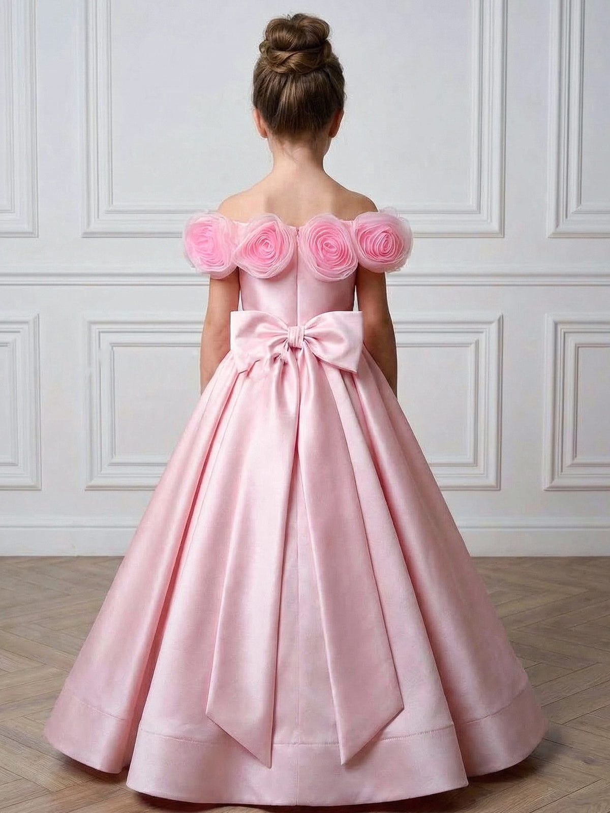 Pink satin girls gown with a large back bow and full ankle-length skirt, designed for weddings and flower girl duties.