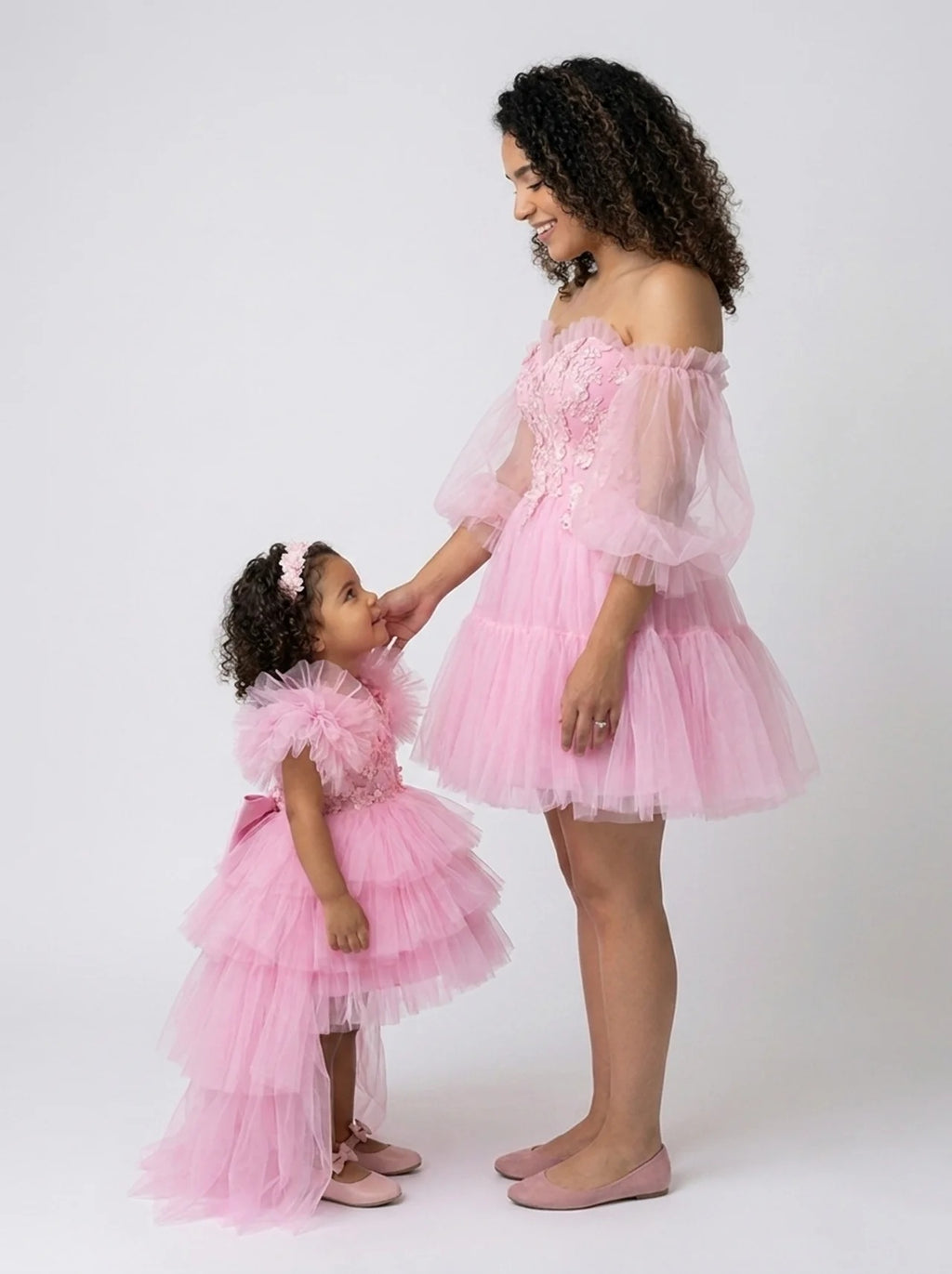 Side profile of the matching pink tulle mommy and daughter dress set showing the girl's trailing high-low hem