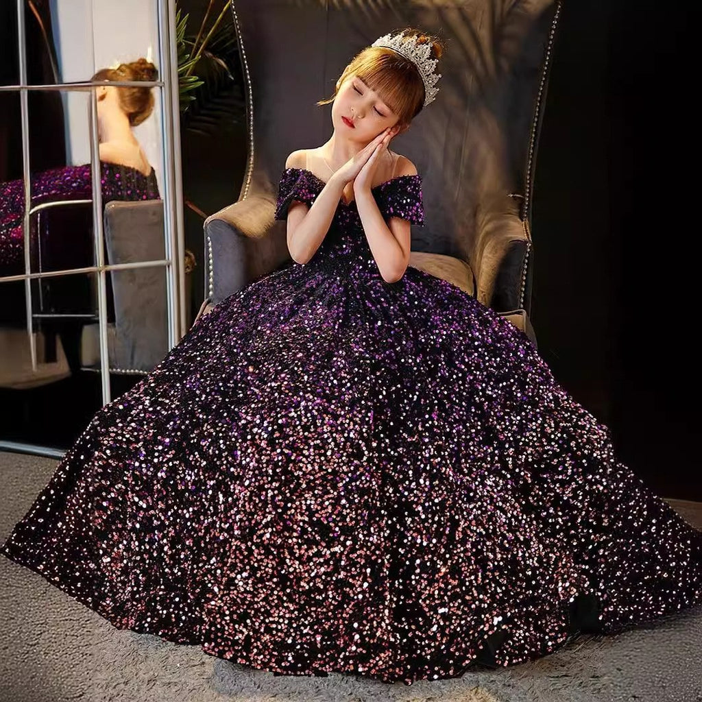 Girl seated in the purple sequin ball gown with the skirt spread around her, for a recital.