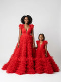 Mother and daughter in matching red ruffled tulle ball gowns with deep V necklines, front view