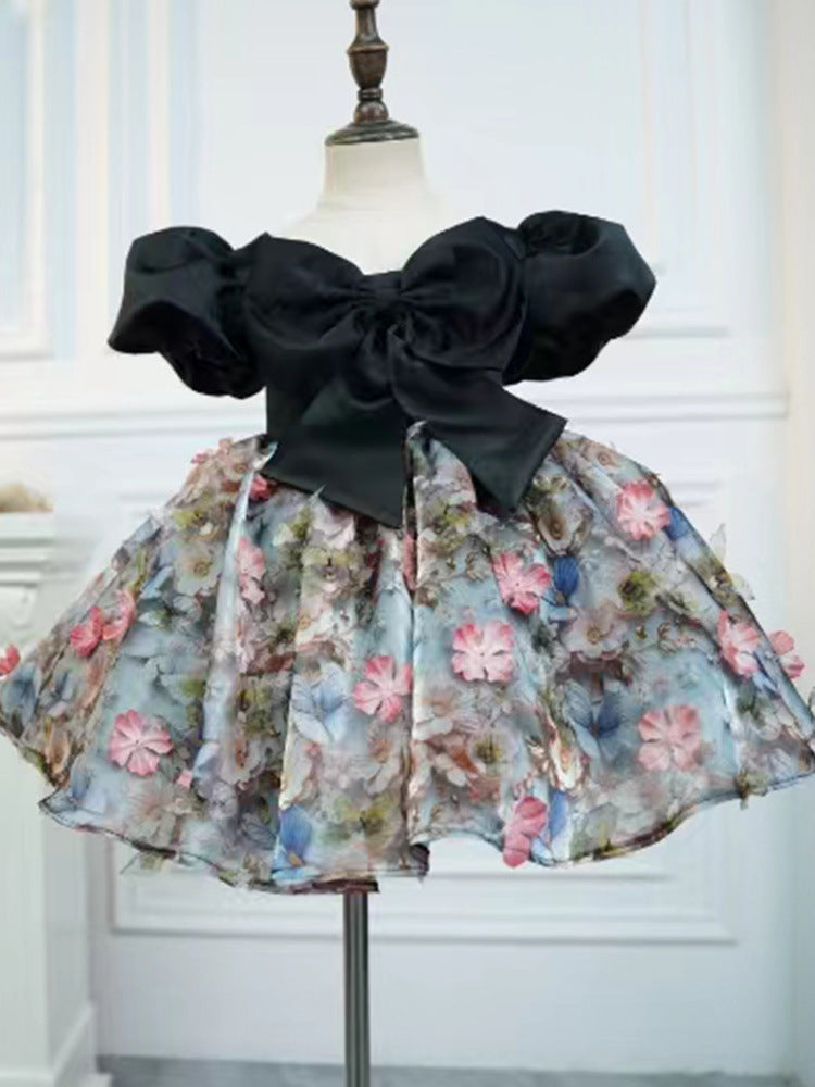 Black satin girls party dress with a bow bodice and full floral skirt, designed for birthday parties and photoshoots.