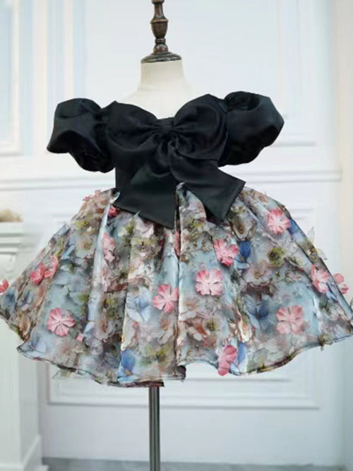 Black satin girls party dress with a bow bodice and full floral skirt, designed for birthday parties and photoshoots.